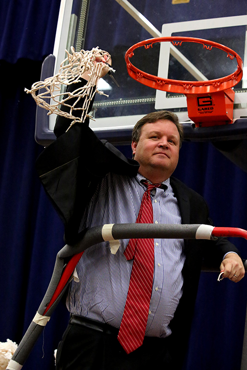 Snead State head basketball coach Jeremiah Patterson cutting the net down.